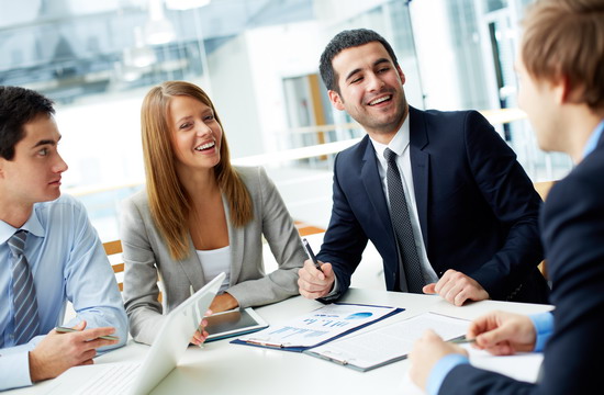 Image of business partners laughing during interaction at meeting